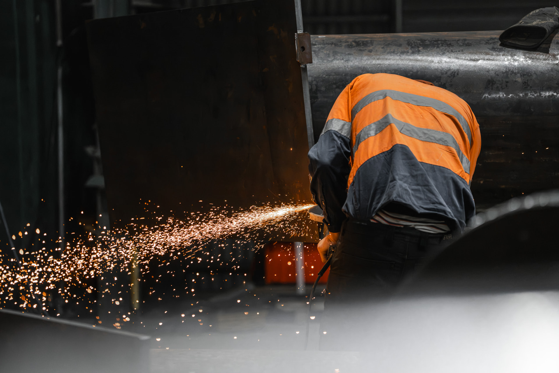 Workshop tradesperson grinding steel with sparks