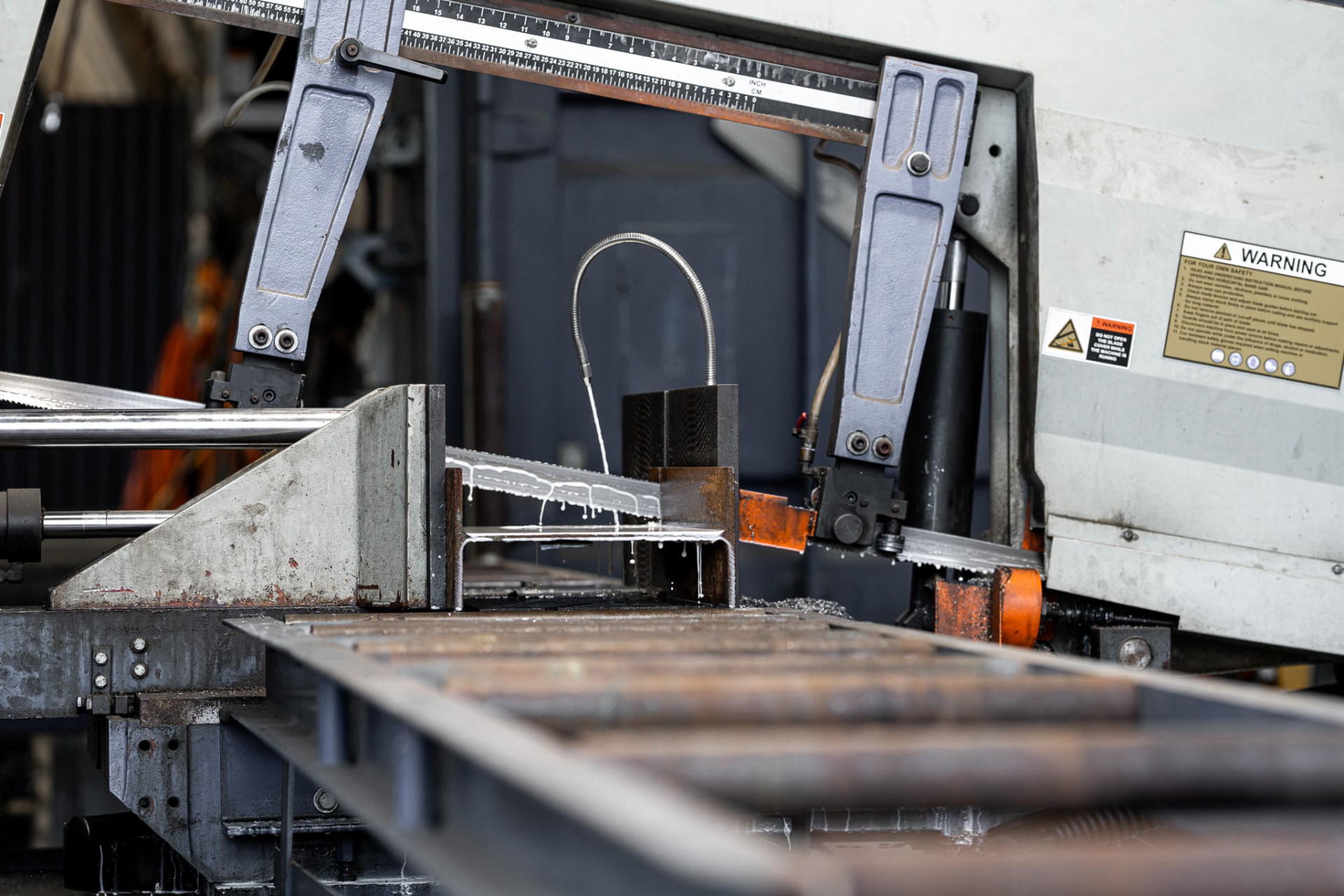 Steel section being cut on a workshop bandsaw during attachment fabrication