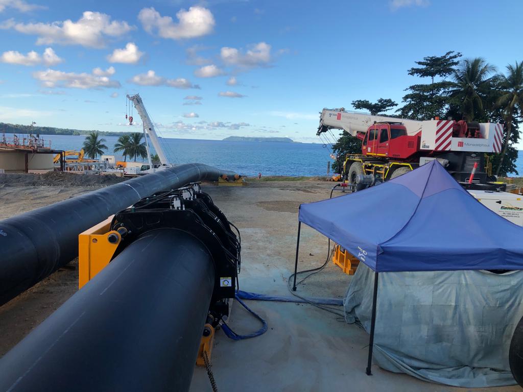 Pipeline equipment and cranes at a coastal worksite