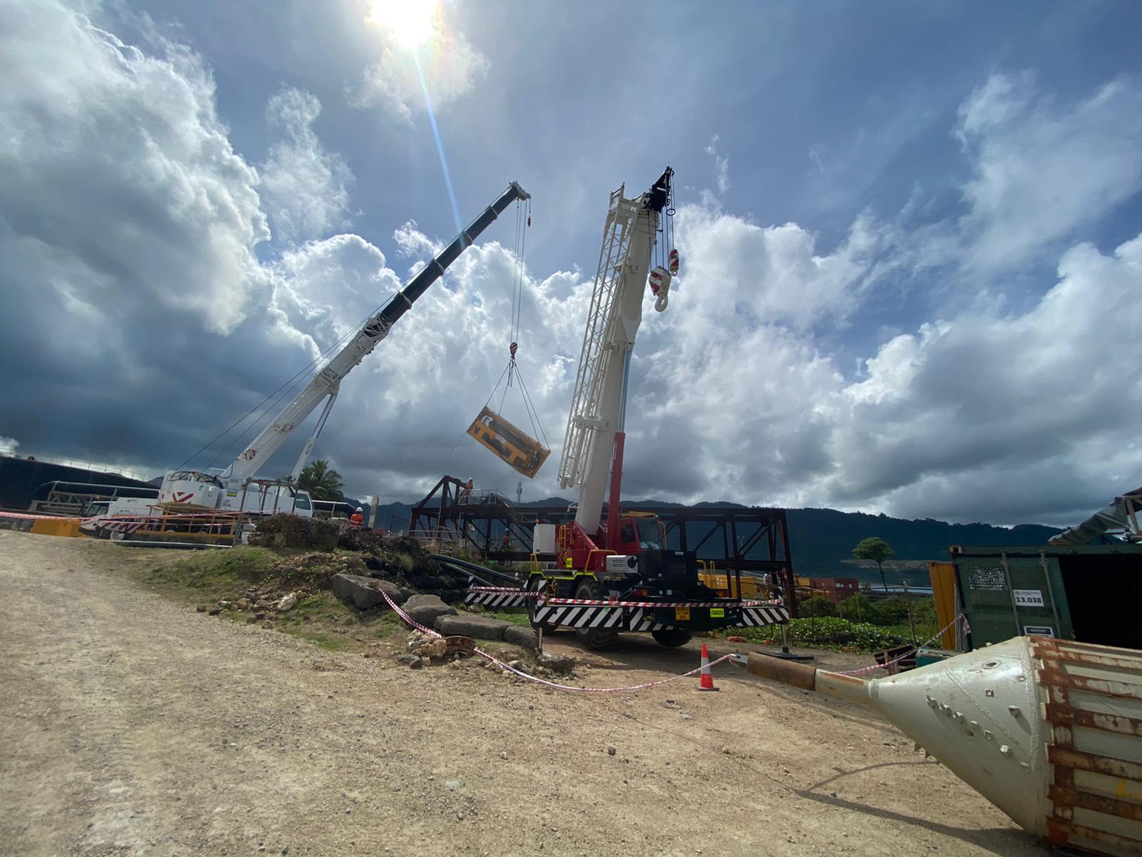 Two cranes completing a heavy lift at a civil worksite