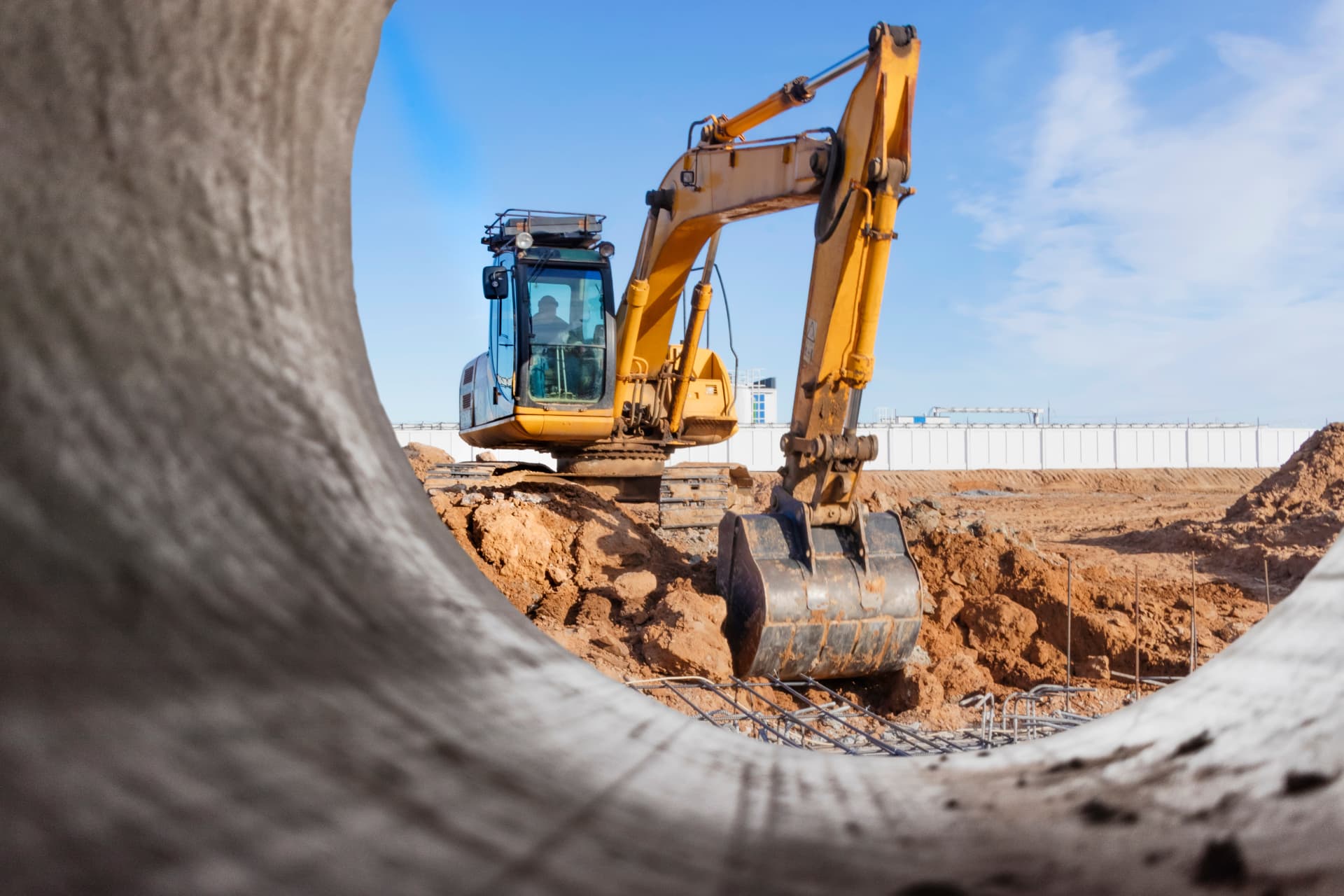 Excavator carrying out trench and earthmoving works on a civil site